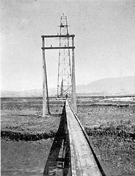 PATROLMEN USE AN ELEVATED WALK OVER MARSH LANDS.