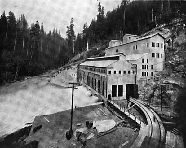 END VIEW OF THE POWER HOUSE SHOWING FOUR GENERATORS IN OPERATION. THIS VIEW SHOWS THE TEMPORARY END WALL AND THE TRENCHING AND GRADING IN PROGRESS AT THE RIGHT TO FACILITATE THE INSTALL ATION OF THE FOUR ADDITIONAL UNITS.