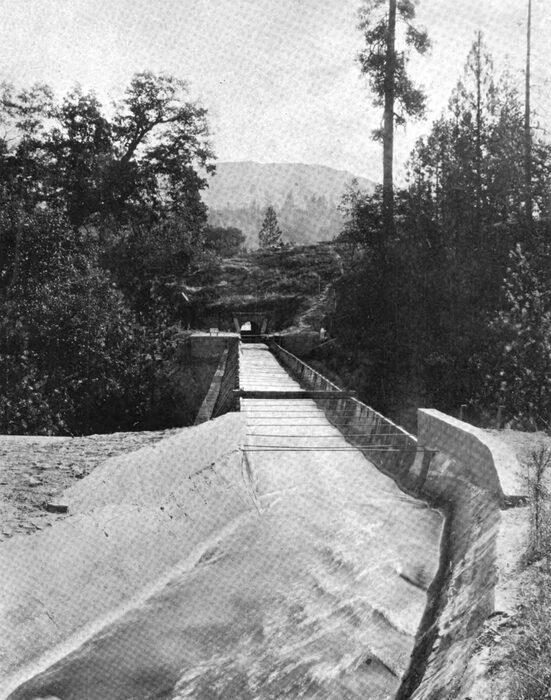 Fig. 5 Ditch, Flume and Tunnel, No. 3 Conduit Line. �Down the Canyon from the Crane Valley dam, beneath the smoky veil in the view in Fig. 2, the conduit extends for 4.22 miles, a part of which is 5 feet wide at the bottom, the remainder being 6 feet in width. The ditch thus formed is in a substantial bed of disintegrated granite the greater part of its length and is plastered with cement."