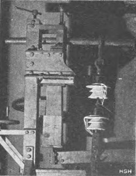 Fig. 24 Simultaneous mechanical and electrical testing of two suspension insulators under 3400 kg load and 5000 V voltage.