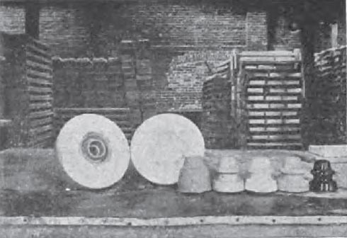 FIG. 2 � HOT PRESS INSULATORS IN VARIOUS STAGES OF PRODUCTION/From left to right: 1�Insulator in mould. 2�Plaster of paris mould. 3�Insulator removed from mould. 4�Insulator trimmed. 5�Insulator bone dry. 6�Insulator glazed. 7�Insulator fired.