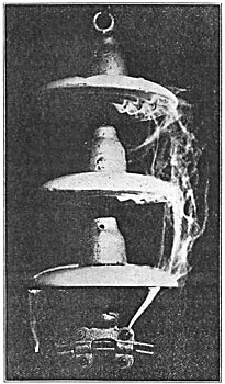 Three-Part Suspension Insulator Undergoing Rain Test at 135,000 Volts.