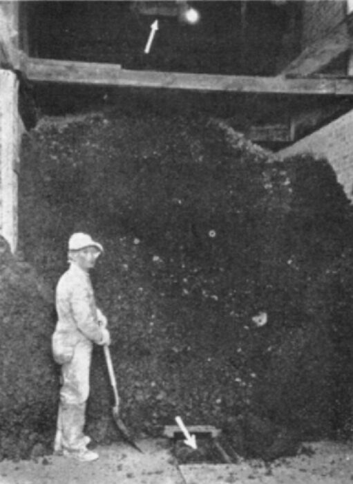 Ball Clay Storage Bin Showing Drag Conveyor Below and Above, Indicated by Arrows.