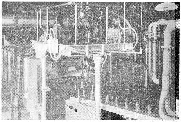 Fig. 14. � Conveyor, stacker and lehr. The bottles at the lower right-hand corner have just emerged from the forming machine and are being stacked automatically on the conveyor belt which will carry them through the long lehr, or oven, to be cooled slowly.