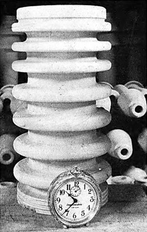 A Sample of the Type of Insulator Made at This Plant. An Alarm Clock is Used for Comparison.