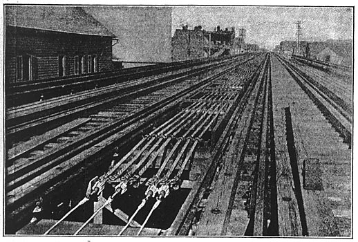 THE TERMINALS OF THE ALUMINUM FEEDERS./The ends of the feeders are soldered into copper connectors with depending lugs to which copper feeders, rising from the ground below, will be soldered. The connectors are bolted to cross bars to which are also fastened steel cables through strain insulators.