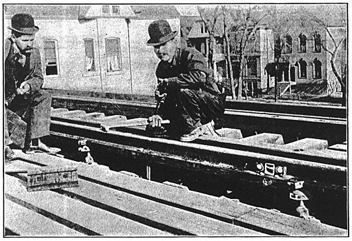 ONE OF THE THIRD RAILS SHOWING THE COPPER TAPS RUNNING TO THE ALUMINUM FEEDERS IN THE MAIN BOXING AND SHOWING ALSO A BOND AND THE INSULATING CHAIRS.
